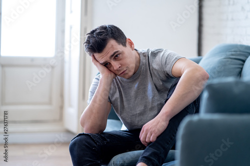 Young attractive man suffering from depression in emotional pain lying on couch at home © SB Arts Media