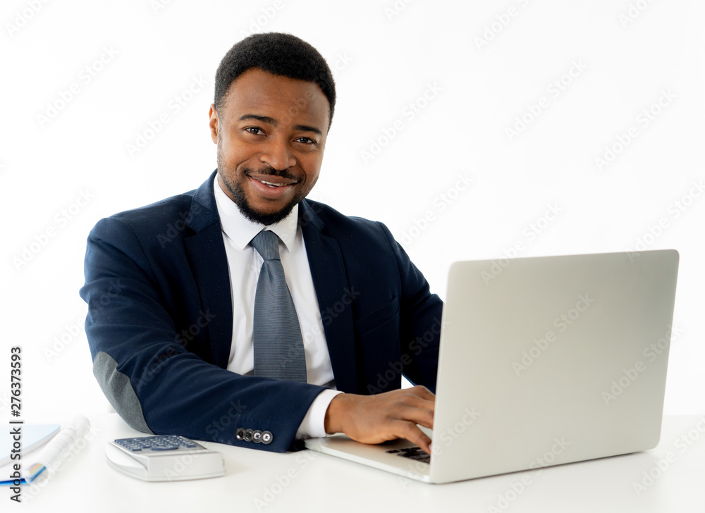 Attractive happy handsome african american businessman working on laptop computer on desk at office Attractive happy handsome african american businessman working on laptop computer on desk at office