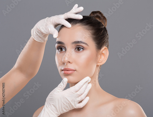 Bild auf Leinwand Cosmetologist checking young woman face before beauty treatment