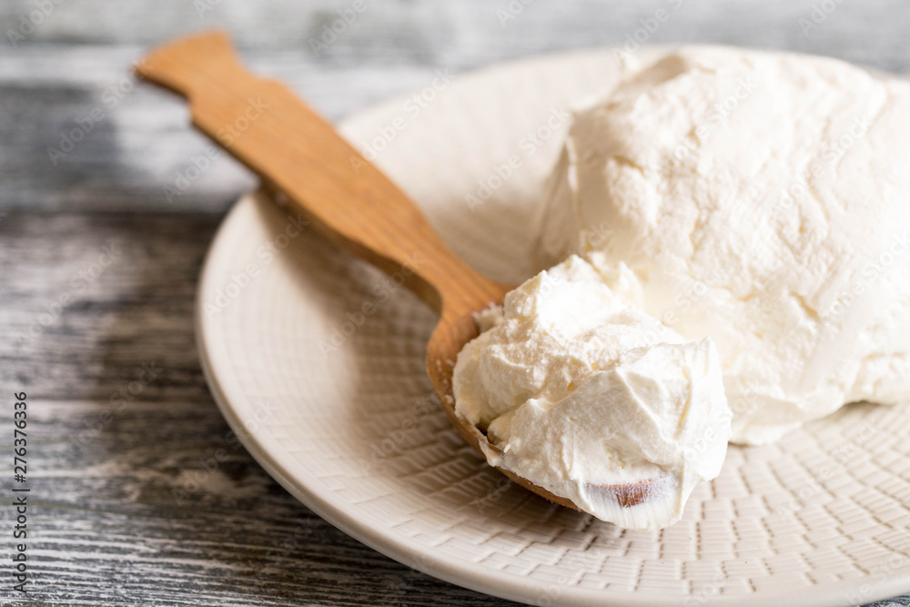Fresh homemade mascarpone. Traditional Mascarpone cheese in wooden spoon Fresh homemade mascarpone. Traditional Mascarpone cheese in wooden spoon