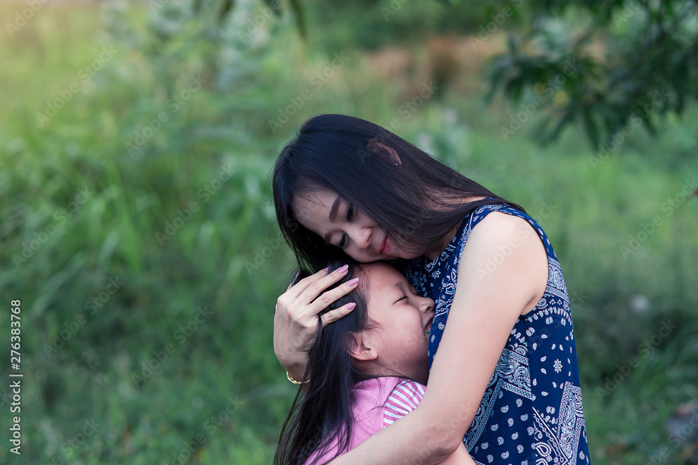 Asian mother and daughter hugging with love  in the park