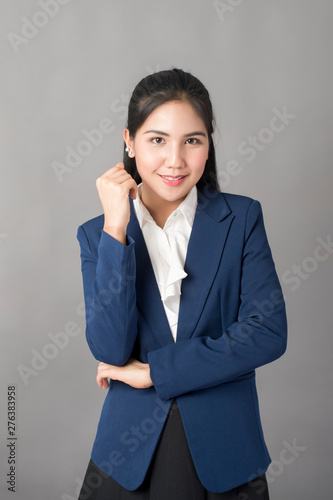 Portrait of smart business woman in blue suit on grey background, studio shot