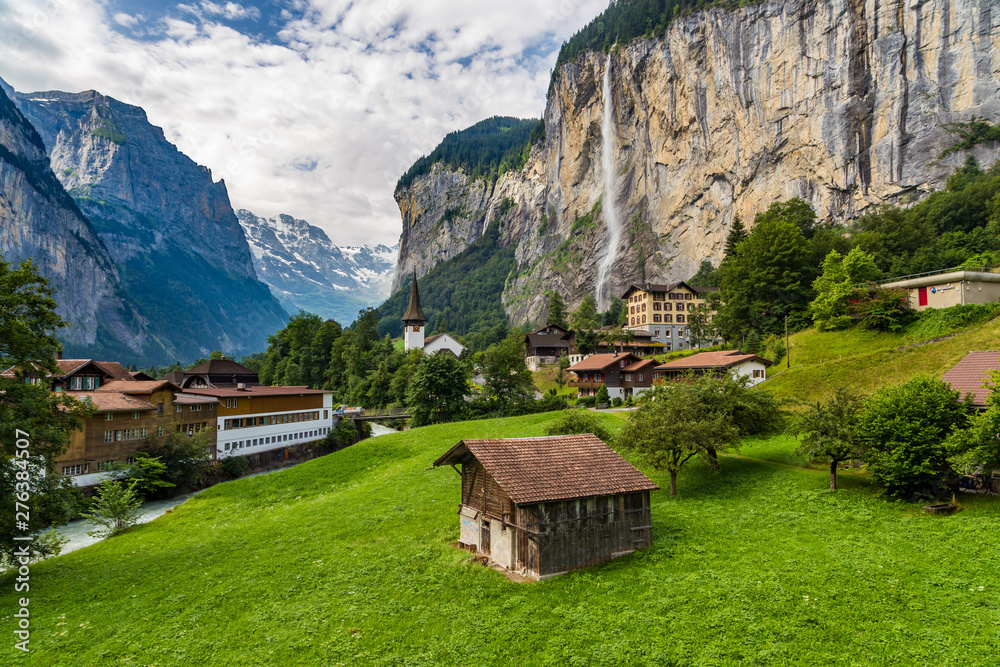 Amazing view of famous Lauterbrunnen town in Swiss Alps valley with beautiful Staubbach waterfalls in the background, Switzerland
