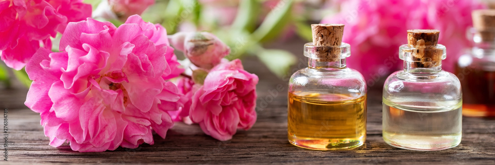 Panoramic header of essential oil bottles and roses - obrazy, fototapety, plakaty 