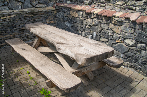 Old brutal table with benches. On the background of masonry. Interior for food