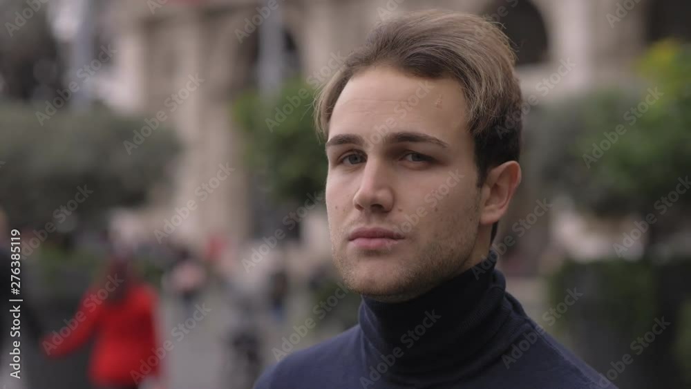 Confident serioius attractive young man in the city,turning, looking at camera Confident serioius attractive young man in the city,turning, looking at camera