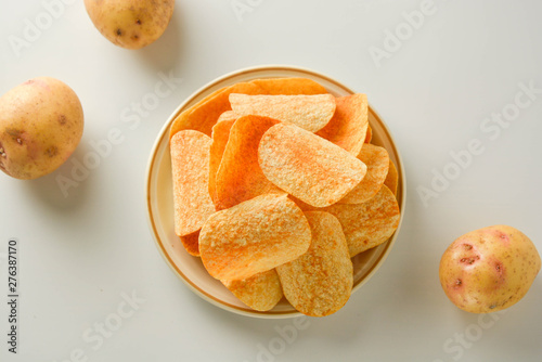 Potato chips in a plate isolated on a white background. Fast food snack.