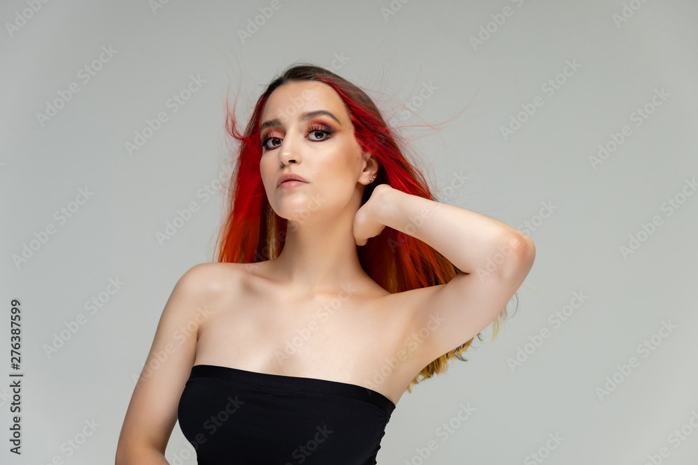 A close-up portrait photo of a fashionable hairstyle red-yellow in studio on a white background. The pretty brunette model with beautiful make-up has beautiful flowing colorful hair. A close-up portrait photo of a fashionable hairstyle red-yellow in studio on a white background. The pretty brunette model with beautiful make-up has beautiful flowing colorful hair.