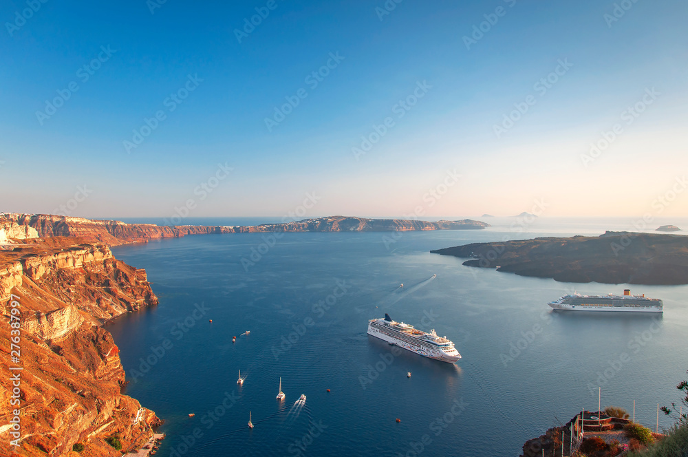 Beautiful landscape with sea view on the Sunset. Cruise liner in the Aegean Sea, Thira, Santorini island, Greece. Summer seascape overlooking the blue sea, caldera and volcano, travel concept