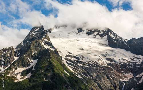 Dombay mountain range in the Caucasus in summer, snow-capped peaks and green mountain slopes