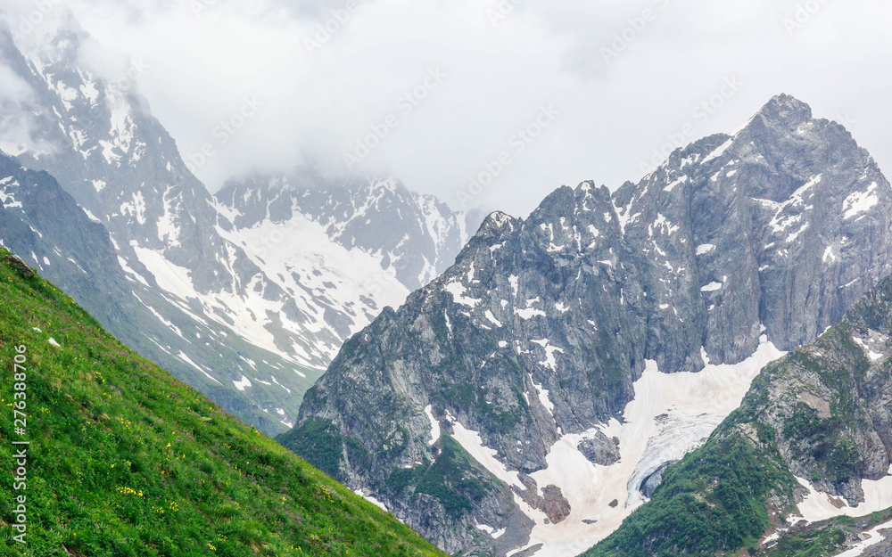 Dombay mountain range in the Caucasus in summer, snow-capped peaks and green mountain slopes