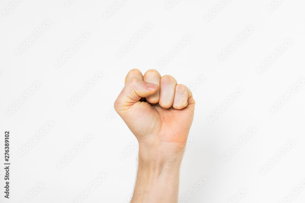 man's hand makes a fist on light grey background man's hand makes a fist on light grey background