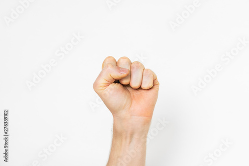 man's hand makes a fist on light grey background