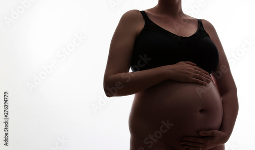 Pregnant woman with a baby bump silhouetted on a white background