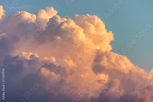 Close up view of beautiful colored dramatic cumulus fluffy clouds on blue sky at sunset background photo