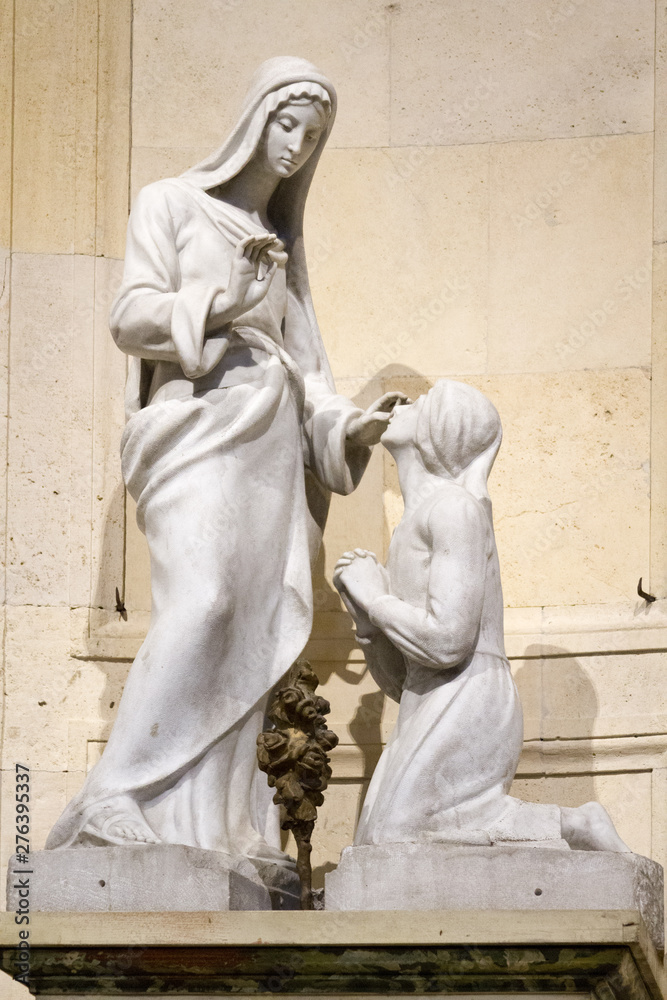 Obraz premium The statue of Virgin Mary blessing Saint Bernadette. The statue is in Duomo di Pavia (cathedral in Pavia, Italy)
