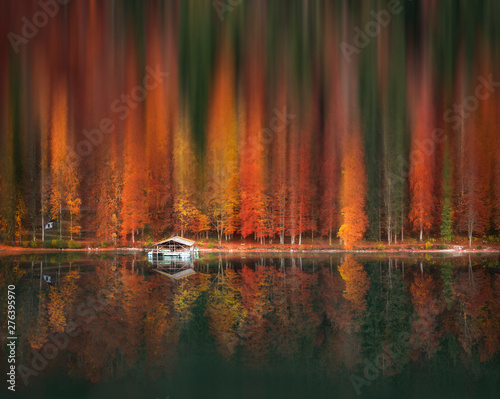 Motion blur autumn forest and water reflection