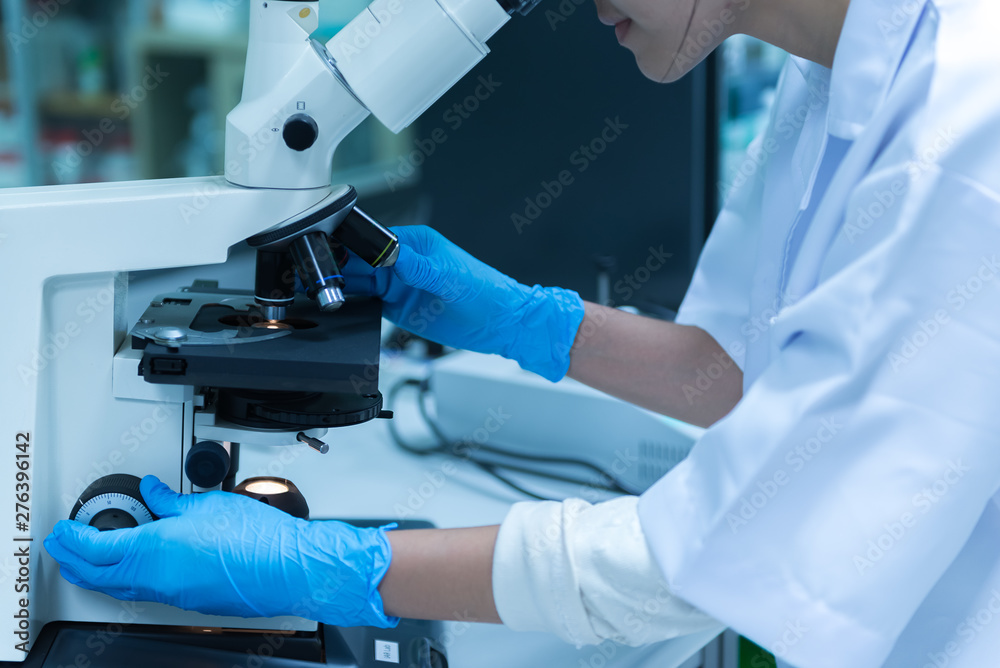 Young asian scientist looking through a microscope in a laboratory.Thailand people doing some research. Young asian scientist looking through a microscope in a laboratory.Thailand people doing some research.
