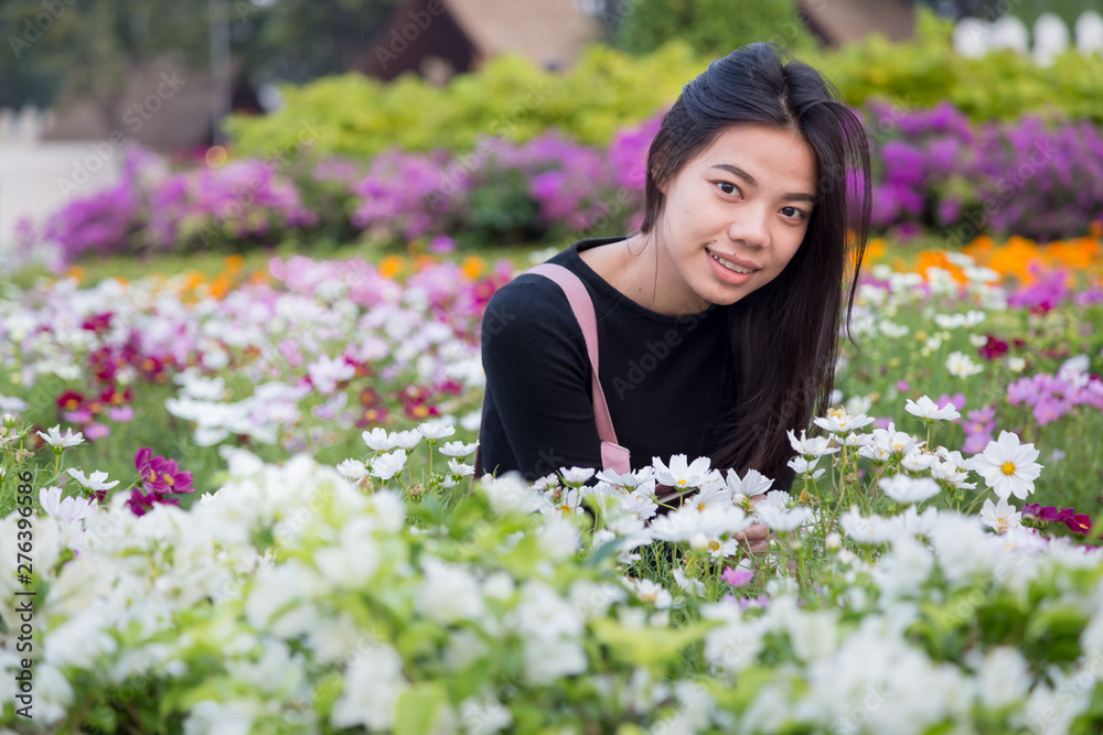 Beautiful Asian girl in pink dress are sitting in the garden flowers at Bangkok , Thailand. Beautiful Women with flowers and nature concept. Beautiful Asian girl in pink dress are sitting in the garden flowers at Bangkok , Thailand. Beautiful Women with flowers and nature concept.