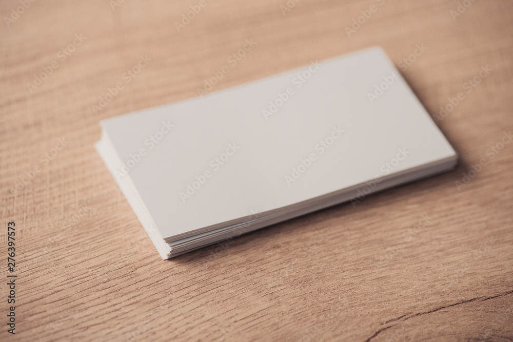 white empty business cards stacked on wooden textured surface white empty business cards stacked on wooden textured surface
