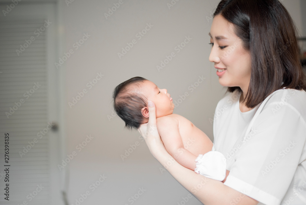 Beautiful woman holding a newborn baby in her arms