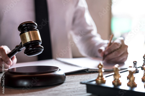 Legal law, advice and justice concept, Professional male lawyers working on courtroom sitting at the table and signing papers with gavel and Scales of justice