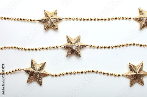 Gold star and bead garland on white backgroun. Flat lay. Top view.