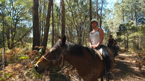 Group of women enjoying a day out in the forest horseback riding. photo