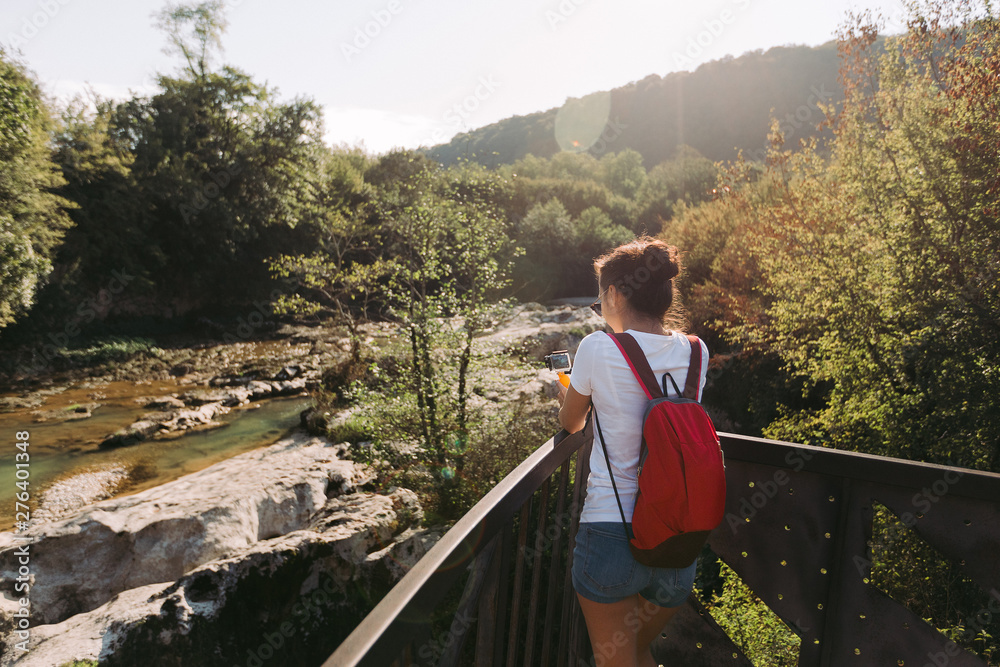 Naklejka premium female tourist with backpack walking in park, Rear view