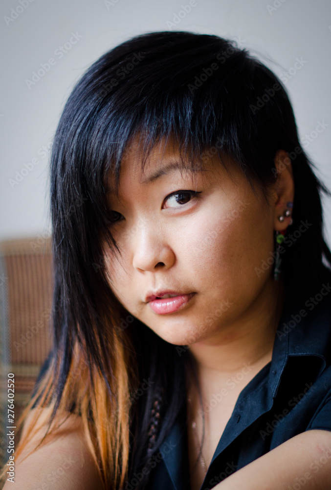 Close up young Asian woman with smiley face, short hair and a red strand Close up young Asian woman with smiley face, short hair and a red strand