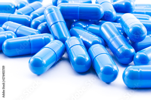 Blue capsules pill on white background. Antibiotics drug resistance.
