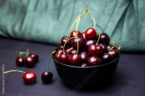 cherries in black containers on the table