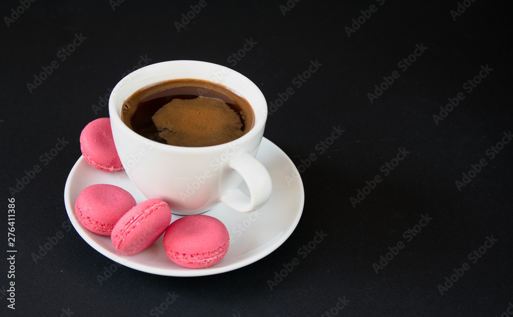 coffee and pink macaroons on a black background coffee and pink macaroons on a black background
