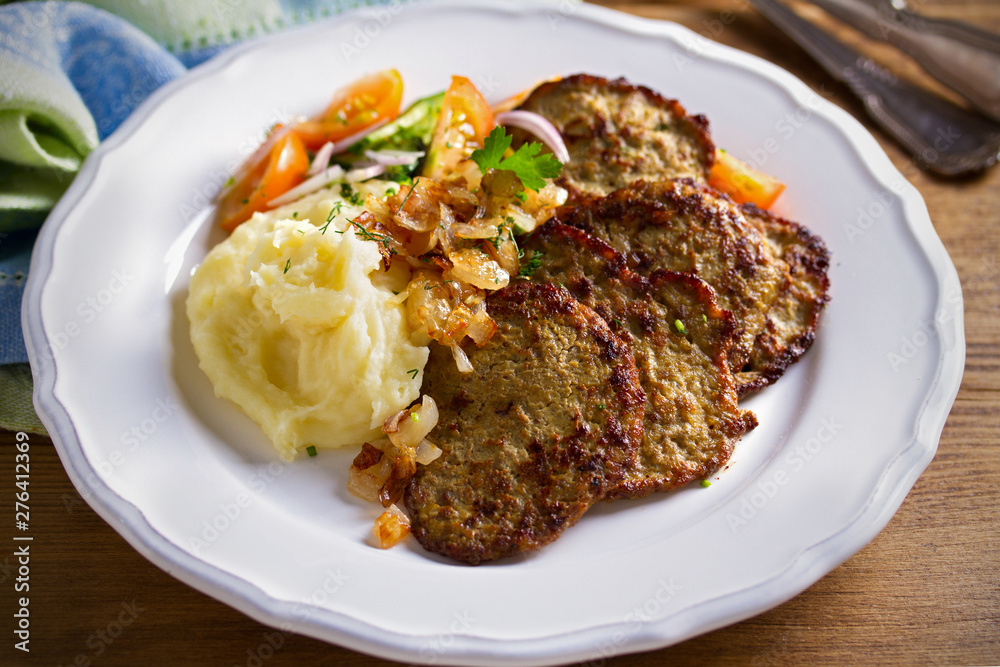 Chicken liver pancakes with mashed potato and vegetables on white plate. Liver side dish Chicken liver pancakes with mashed potato and vegetables on white plate. Liver side dish