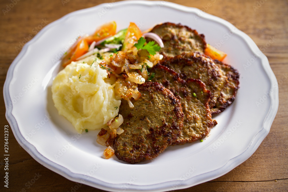 Chicken liver pancakes with mashed potato and vegetables on white plate. Liver side dish Chicken liver pancakes with mashed potato and vegetables on white plate. Liver side dish