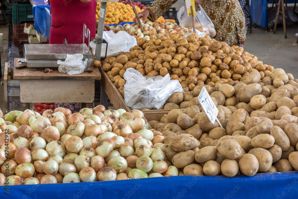 Gemüsestand auf einem regionalen Wochenmarkt mit Zwiebeln und Kartoffeln