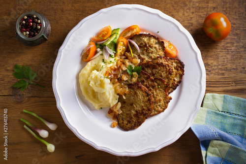 Chicken liver pancakes with mashed potato and vegetables on white plate. Liver side dish