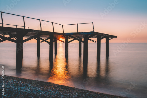 Pier in to the sea. Beautiful evening on the beach, Sunrise with orange color and long exposure sea waves. Georgia, Batumi, Adjara