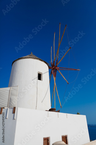 Old white windmill in Oia over blue sky in Santorini, Greece