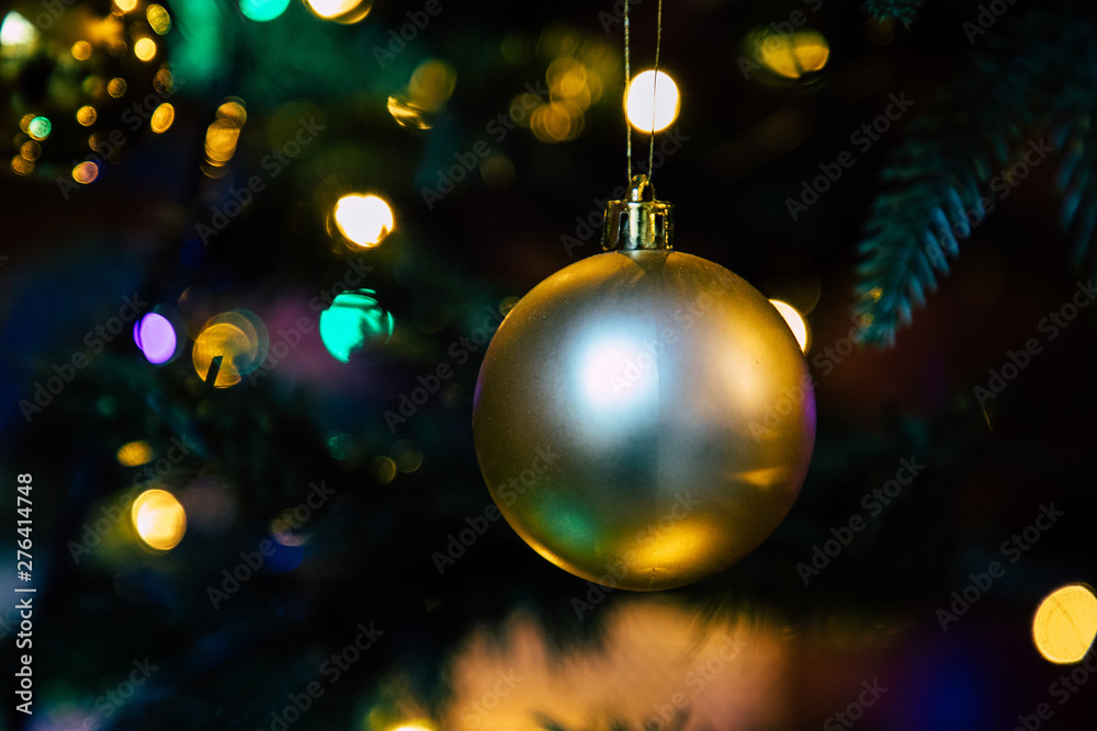 Fototapeta premium Golden decoration globe on christmas tree close up