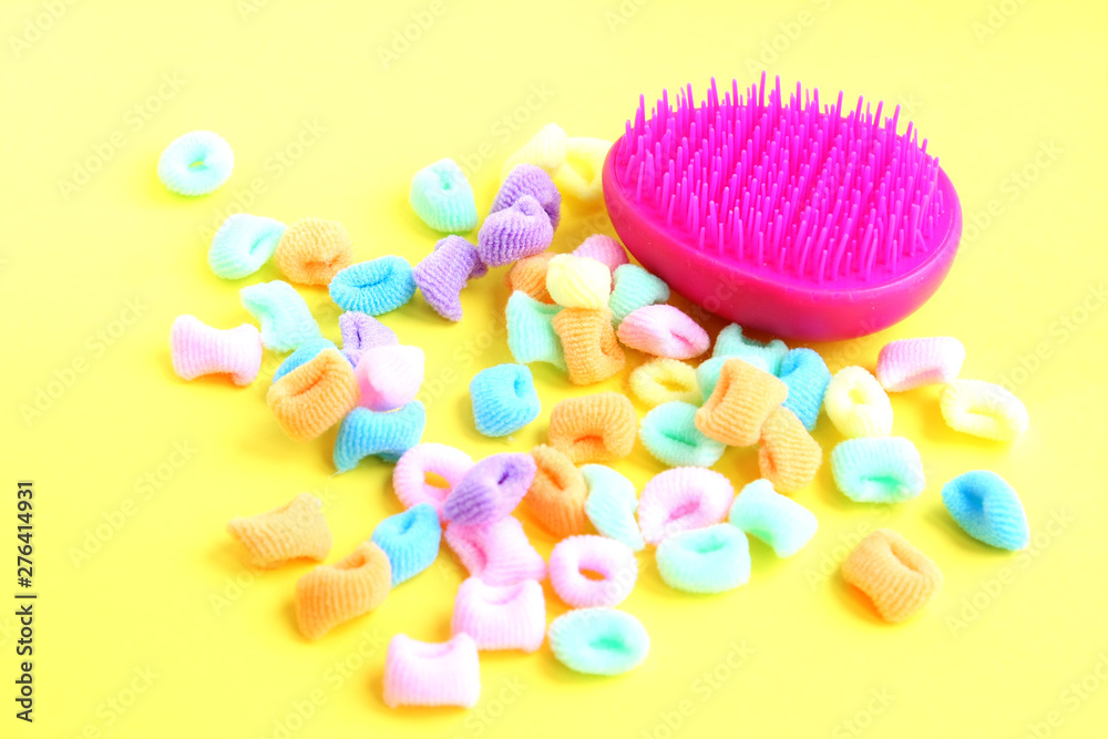 Pink comb and bright multi-colored scrunchies on white background Pink comb and bright multi-colored scrunchies on white background