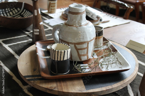 A setting of hand made pottery rests on a lazy susan.