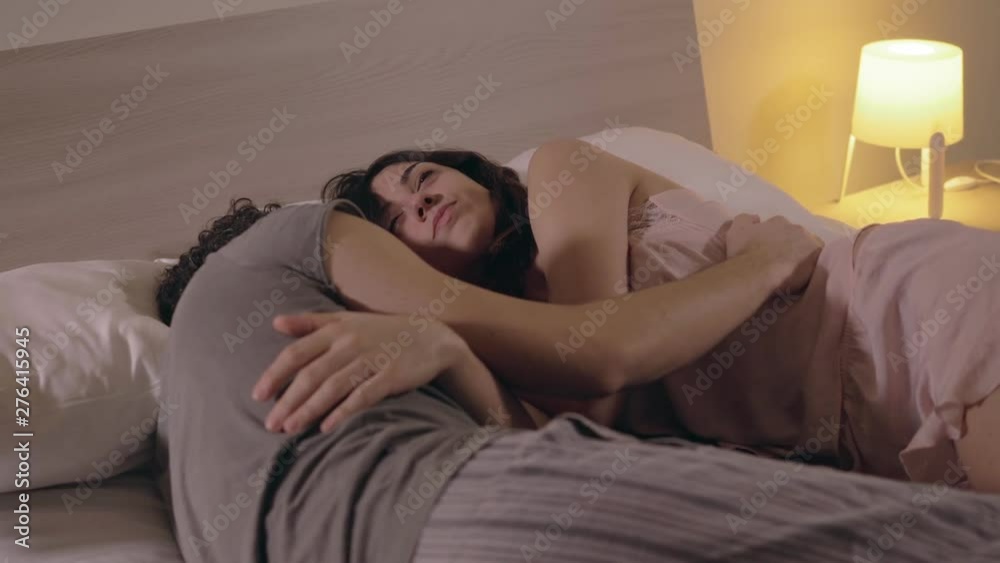 Love, tenderness,cuddles.Young lovers lying on bed cuddling Love, tenderness,cuddles.Young lovers lying on bed cuddling