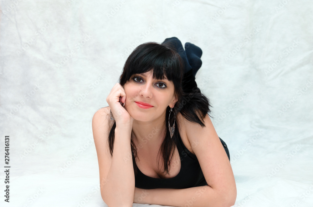 Portrait of a young beautiful woman, smooth healthy skin with minimal makeup, naturalness and beauty. Charming brunette on a gray background, lying on the floor. Portrait of a young beautiful woman, smooth healthy skin with minimal makeup, naturalness and beauty. Charming brunette on a gray background, lying on the floor.