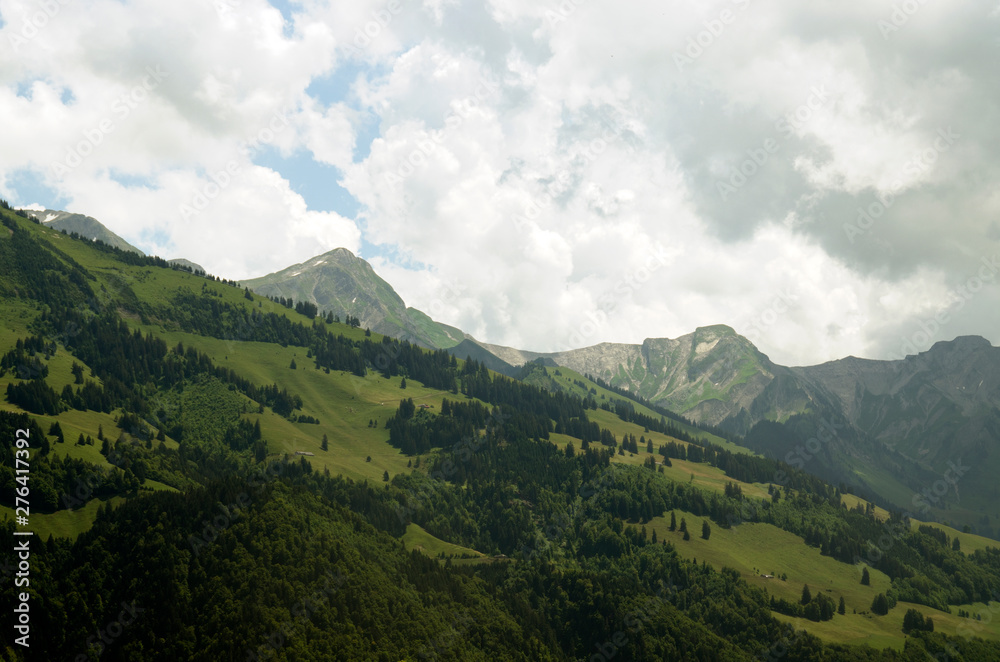 Beautiful mountain landscape in the background of the cloudy sky. Alps mountains in Switzerland. Summer background.