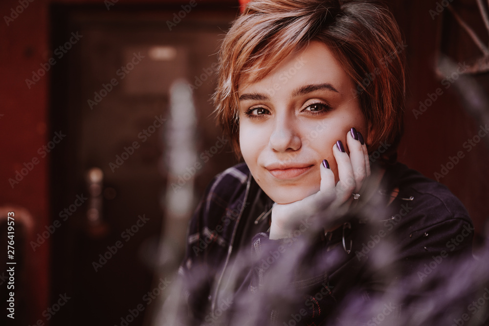 Outdoor portrait of young beautiful woman with short red hair posing ...