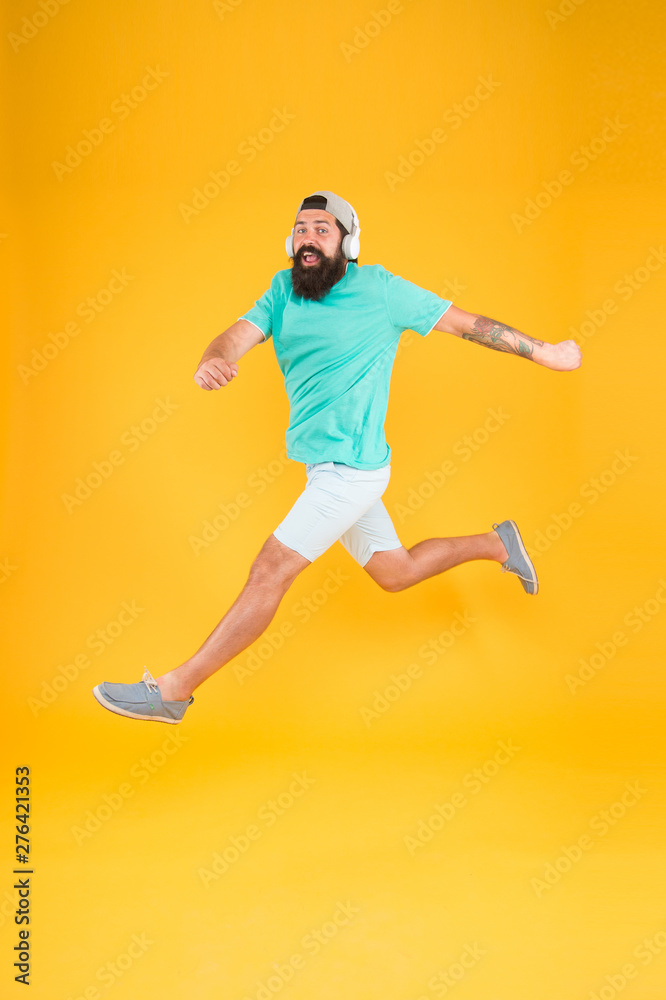 Bearded guy enjoy music. Impetuous movement. Hipster dancing jumping headphones gadget. Inspiring song. Music library. Energy of rhythm. Music fan. Man listen music wireless headphones in motion