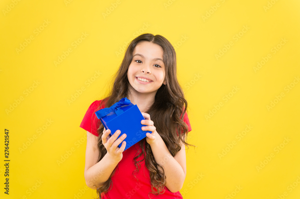Shopping to find the perfect gift. Cute kid enjoying shopping. Shopping addict with present wrapped in blue box. Little girl after shopping for gift. Small child holding gift box on yellow background Shopping to find the perfect gift. Cute kid enjoying shopping. Shopping addict with present wrapped in blue box. Little girl after shopping for gift. Small child holding gift box on yellow background