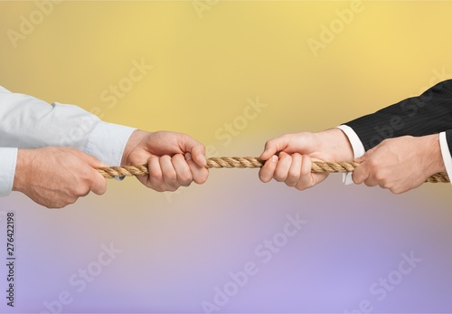 Business men hands holding rope on grey background