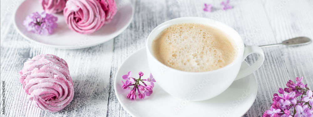 Bouquet of lilacs, cup of coffee, homemade marshmallow Romantic spring morning Selective focus Horizontal banner Bouquet of lilacs, cup of coffee, homemade marshmallow Romantic spring morning Selective focus Horizontal banner